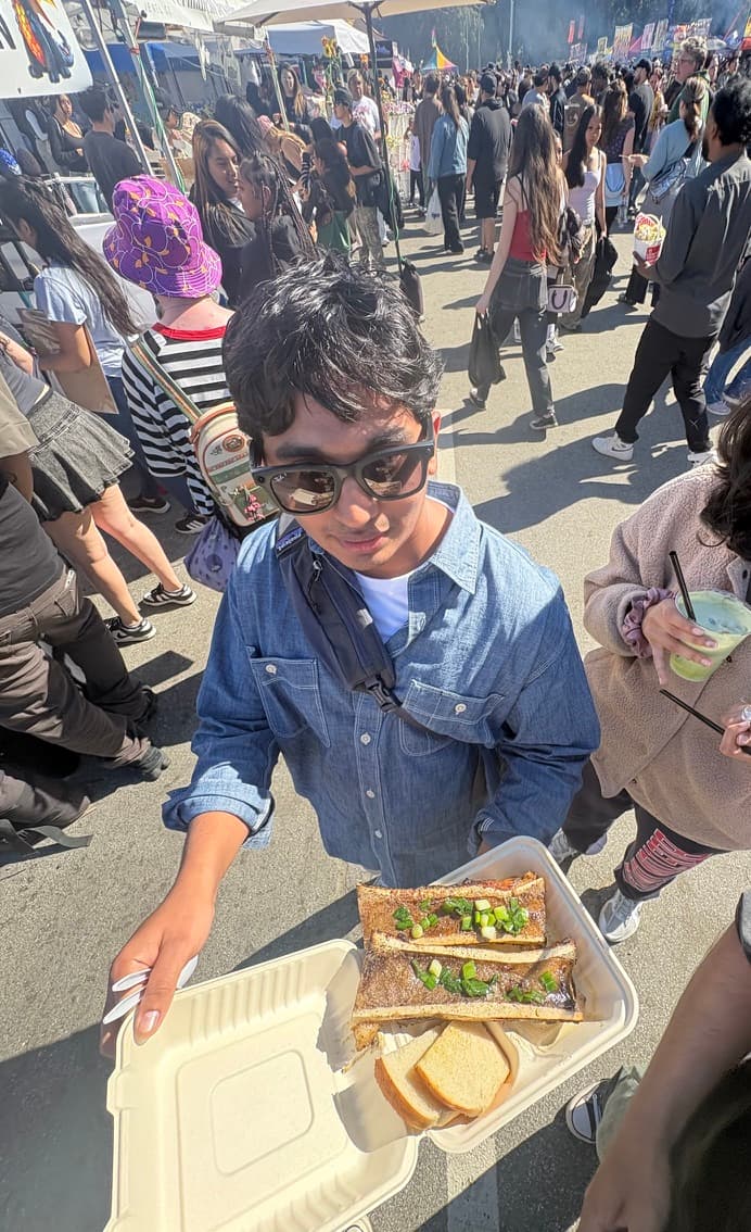 Ananth holding a tray of grilled short ribs at a street food festival